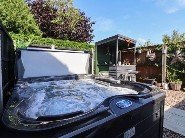 A garden with a hot tub and a wooden shed at 3 Mill Lane with HT Grimsby