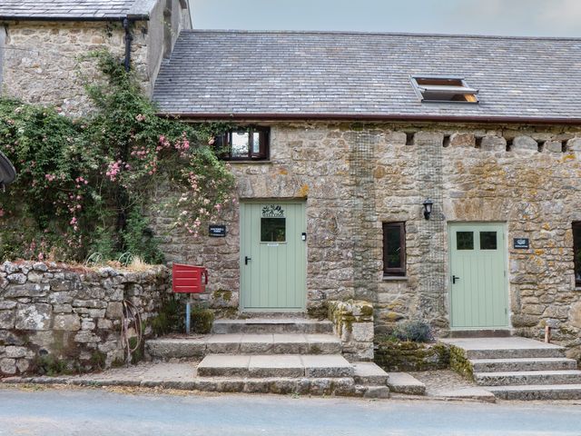 An outdoor view of a stone building with green doors at Brimble Cottage at Dockwell Farm, Newton Abbot