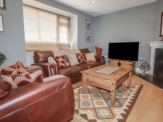 A living room with a sofa and coffee table at 1 Grenville Road in Truro
