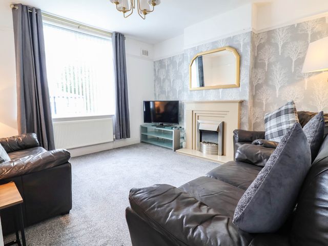 A living room with a sofa and television at 29 Vale Road, Ellesmere Port