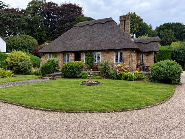A house with a thatched roof and garden at Tudor Lodge near Belper