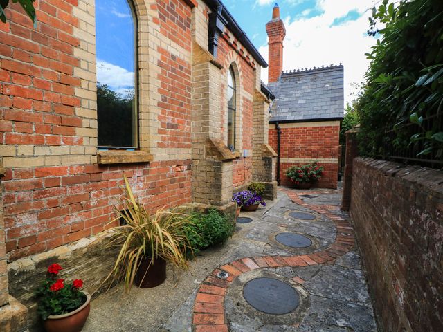 An outdoor pathway with flower pots and brick walls at The Sunday School Room in Sherborne