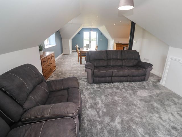 A living room with a sofa and a dining table at 6 Coswinsawsin Lane near Camborne