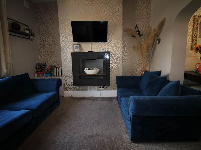 A living room with sofas and a television at The Trafalgar in Scarborough