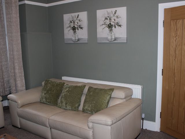 A living room with a sofa and wall art at Blackburn Heights Apartment 1 in Bridlington
