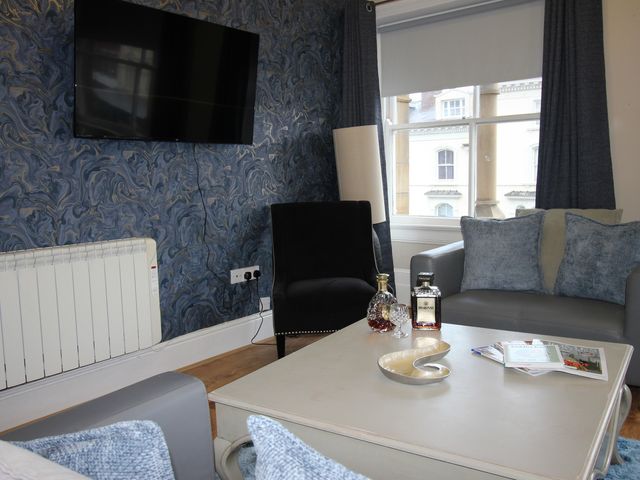 A living room with a television and seating at Cornerhouse Apartment 2 in Llandudno