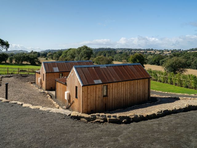 Two wooden cabins with gravel path and landscape at 2 West Dunkirk Neuk in Humshaugh