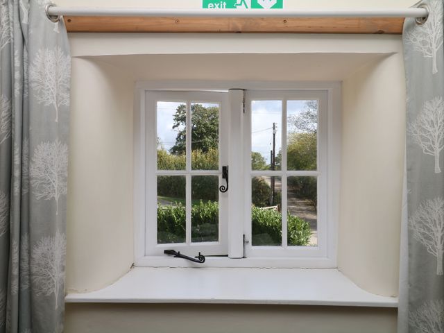 A window with a curtain and exit sign at The Cheese House near Charmouth