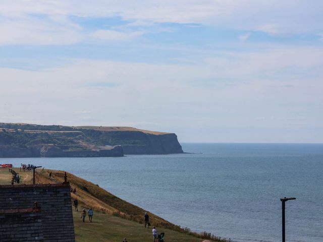 A view of the sea and cliffs with people walking at 26 Metropole Towers in Whitby