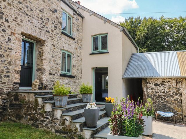 A house exterior with stone wall and planters at Little Moorgate Okehampton