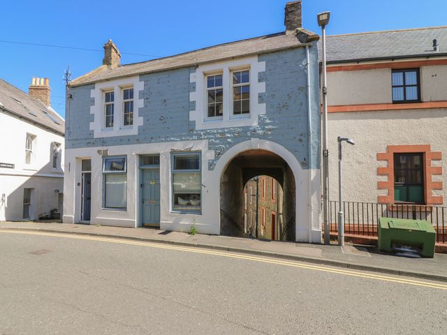A building with windows and an archway on the street at The Herring's Lean in Eyemouth