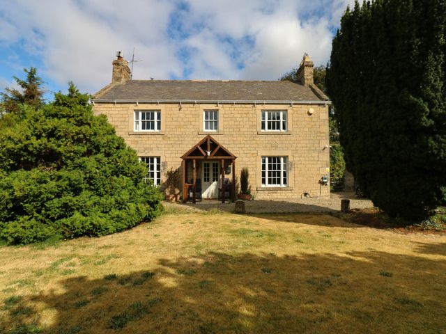 A house with a front porch and garden at Prudhoe Cottage in Prudhoe