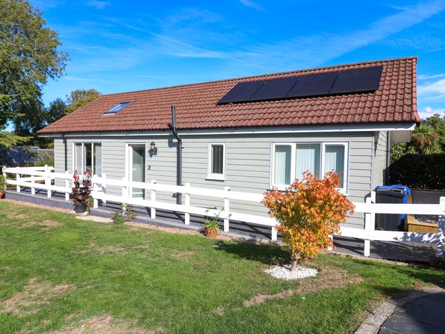 A house with solar panels in a garden at Jasper Lodge in Welton