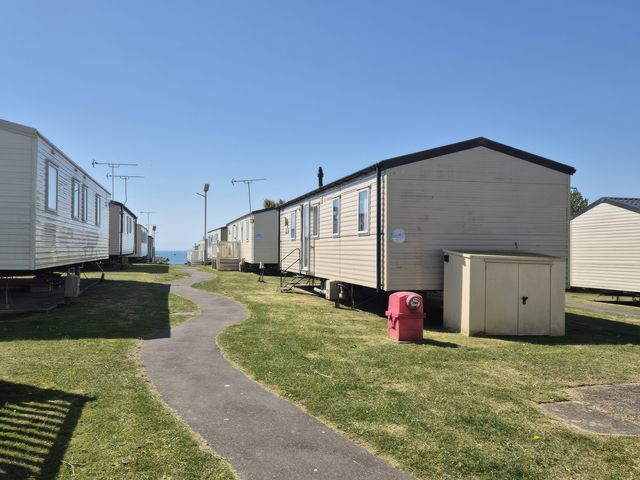 A row of mobile homes alongside a pathway at 67 Harley Mead St Leonards-On-Sea