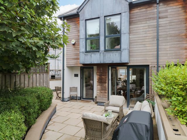 An outdoor patio with seating and grill at Beachstone in Salcombe