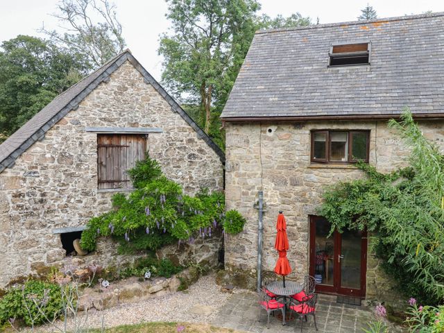 A stone building with a patio area and table near Dashel Cottage at Dockwell Farm near Widecombe-In-The-Moor