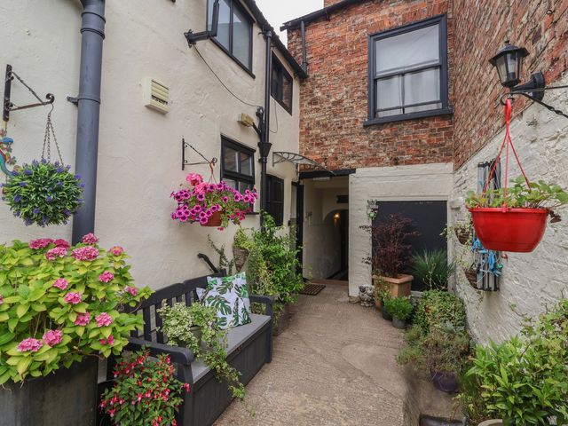 An outdoor area with a bench and plants at Cathedral Mews Ripon