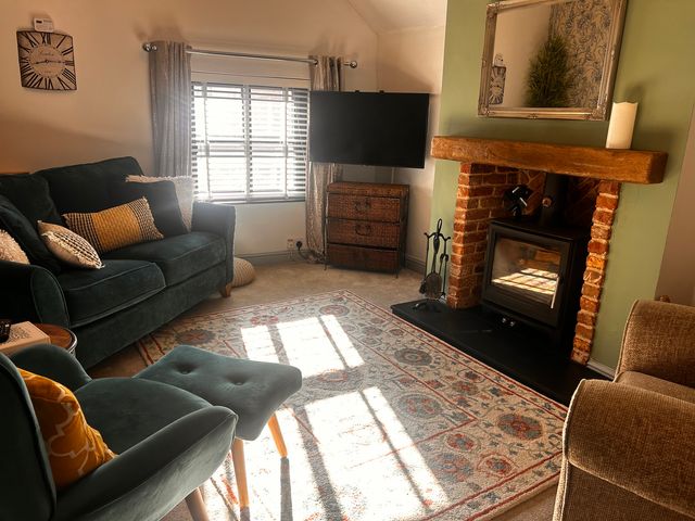 A living room with a fireplace and television at Old Cottages: 3 Bed in Ripon