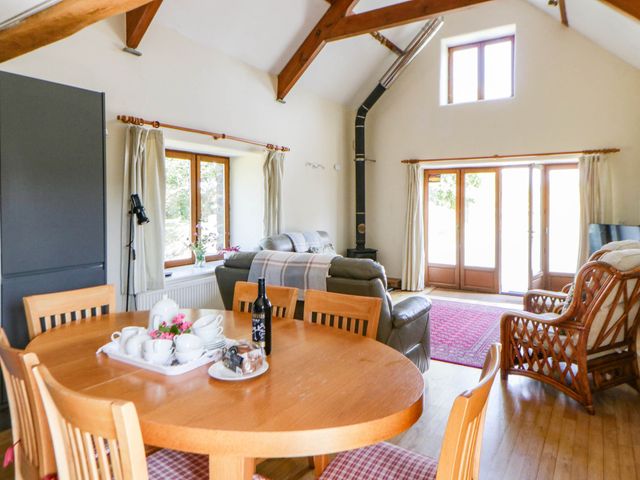 A living room with a table and chairs at May Cottage in St Davids
