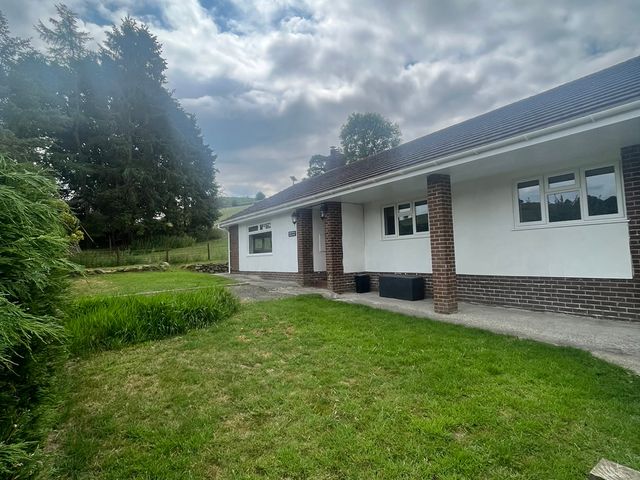 A garden with a bungalow in Llandrindod Wells Saddleback Bungalow