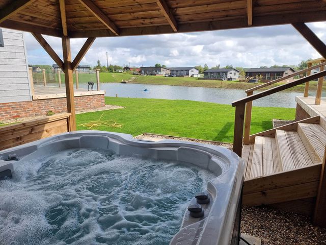 A hot tub with a view of a lake at Pet Friendly 2Bed Luxury Lodge in Routh HotTub Heron Lakes Luxury Lodge Park near Beverley