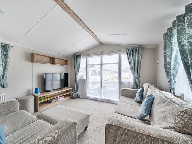 A living room with a sofa and television at Primrose Valley 3Bed Caravan Sleeps 8 Pets Ok in Primrose Valley