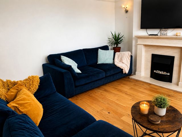 A living room with a sofa and television at 3Bed House Sleeps 7 Parking Garden Pets Ok in Lytham St. Annes