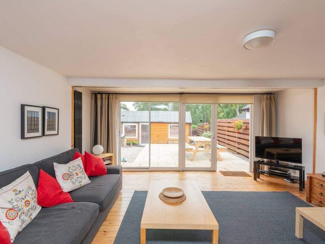 A living room with a sofa and television at 2bed Cottage Private garden Freeparking in Aviemore
