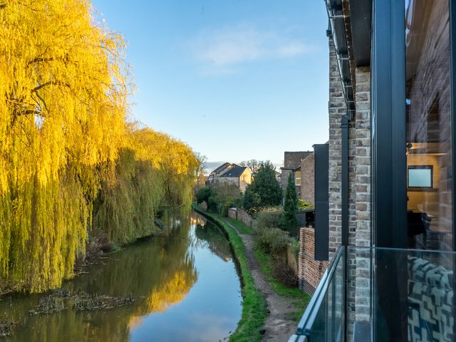 A view of a canal with trees and houses at The Old Barn in Manchester