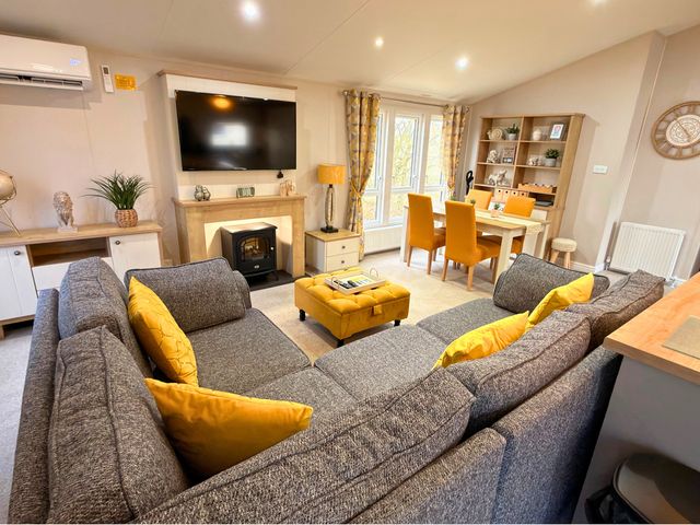A living room with a sofa and television at Meadows 33 Hot tub Southview Holiday Park in Skegness