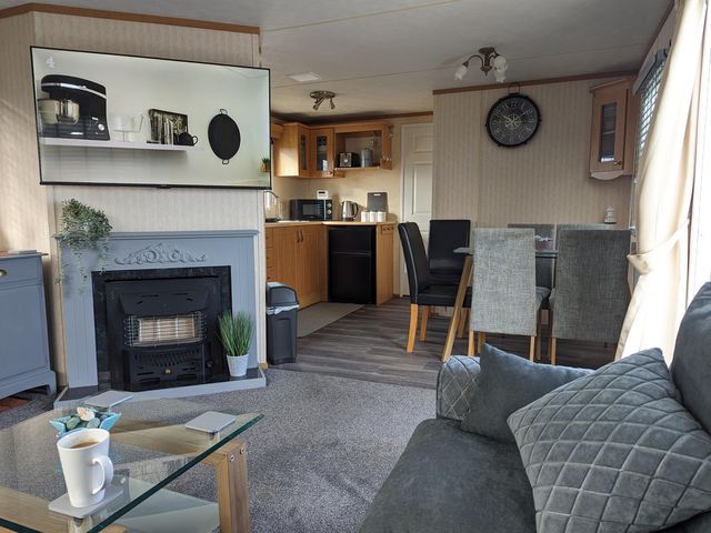 A living room with a kitchen area and furniture at the property