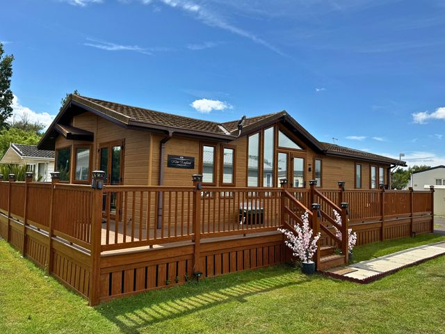 A wooden lodge with decking and stairs at '' in ''