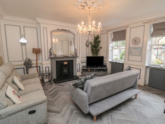 A living room with a sofa, coffee table, television, and fireplace at The Hyding Place in Whitby
