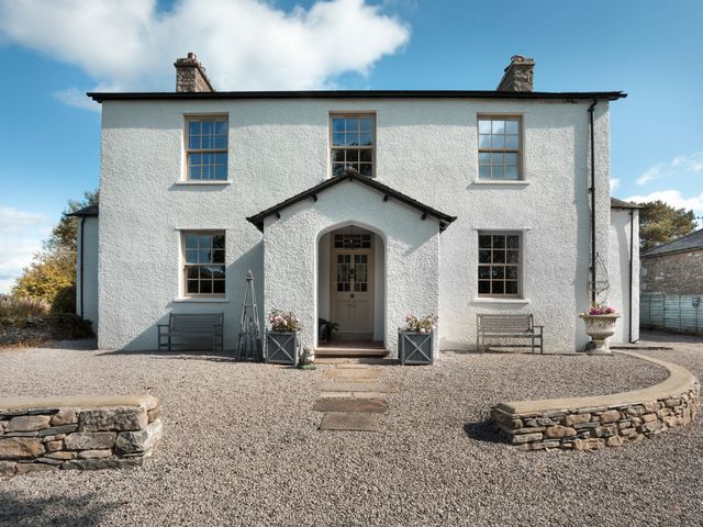 A house with a front door and windows at Three Mile House in Carnforth