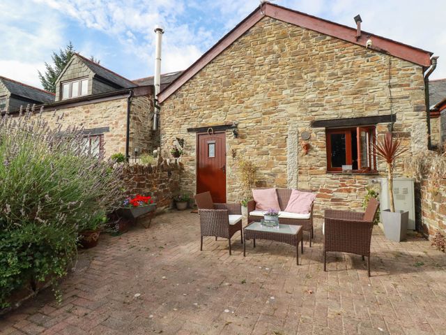 An outdoor area with stone wall and patio furniture at Skylark in Liskeard