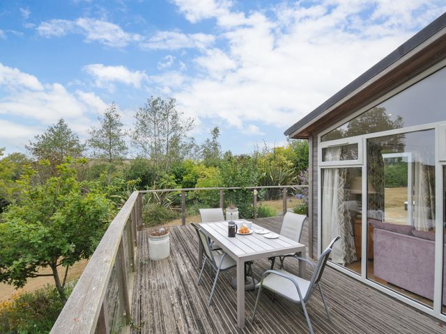 An outdoor deck with a table and chairs at 5 Tree Tops in Dobwalls