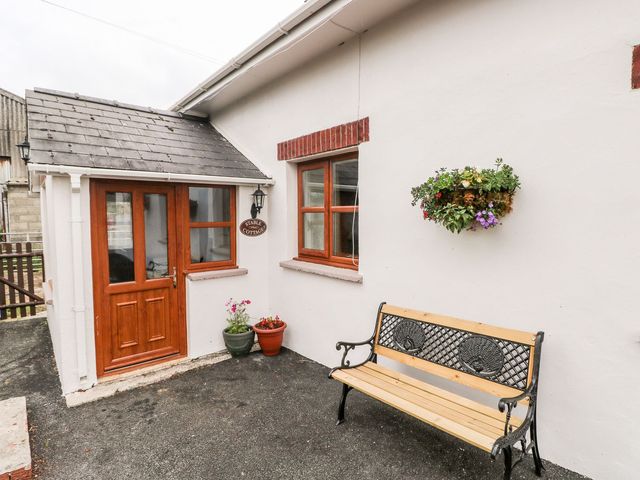 An entrance area with a bench and flowers at The Stable in Haverfordwest