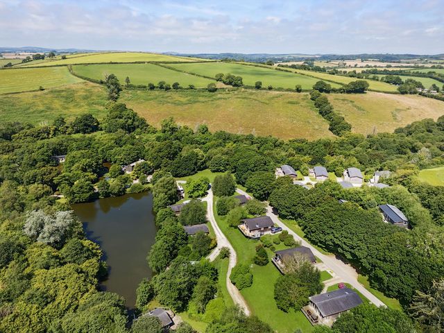 An overview of houses surrounding a pond and greenery at 7 Stonerush Valley Looe