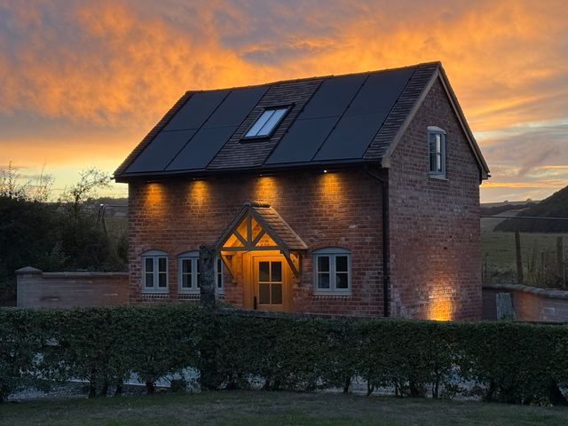 A house with solar panels and hedges at Little Red Barn in Wallop near Westbury