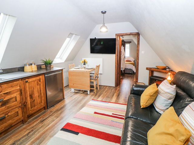 A studio with kitchen, dining area, and sofa at Little Mill in Ashover
