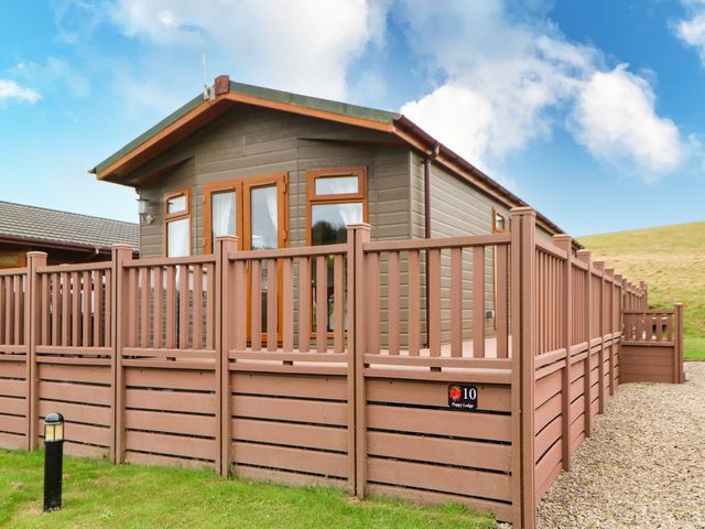 An outdoor area with a lodge and a surrounding fence at 10 Poppy Lodge in Richmond