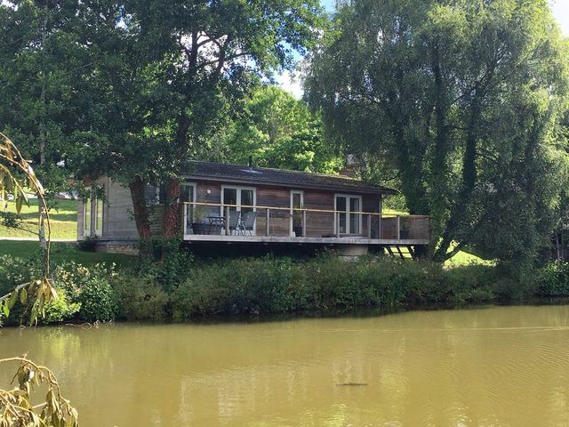 A house with a deck by a pond at 1 Water's Edge