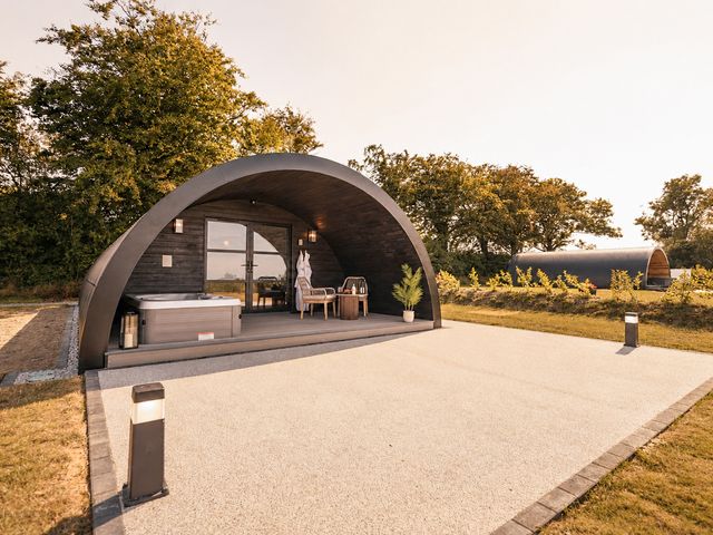 An outdoor area with hot tub and seating at The Hog Hut in Llanarth
