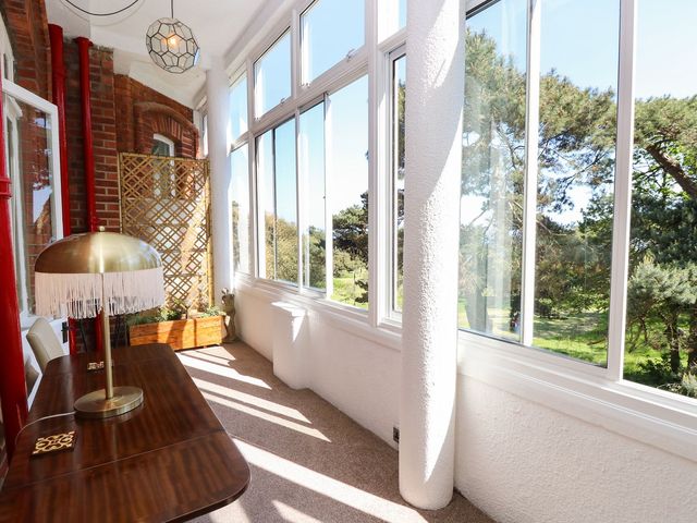 A sunroom with a table and lamp at The Pines in Bournemouth