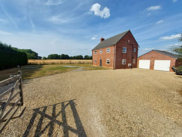 A house and garage in a gravel driveway at Wold View in Market Rasen