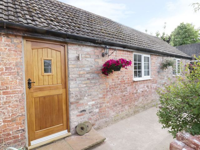An entrance with a wooden door and a window at Millstone Cottage in Beverley