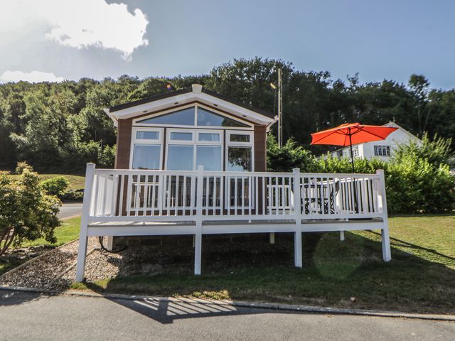 A house with a deck and an umbrella at 73 Cildraeth in New Quay