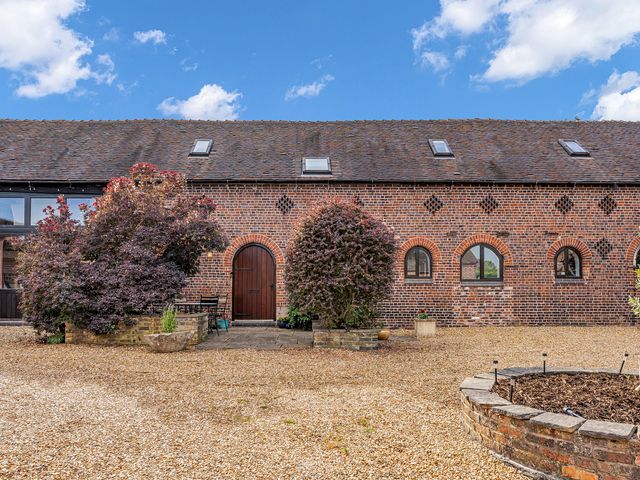 An exterior view of a brick barn with door and windows at Oxhay Barn Newcastle