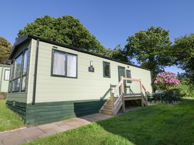 A mobile home with stairs and patio furniture at Feather Tor in Tavistock