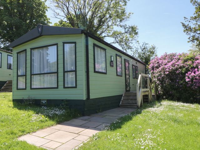 A mobile home with steps and flowers at Laughter Tor Tavistock